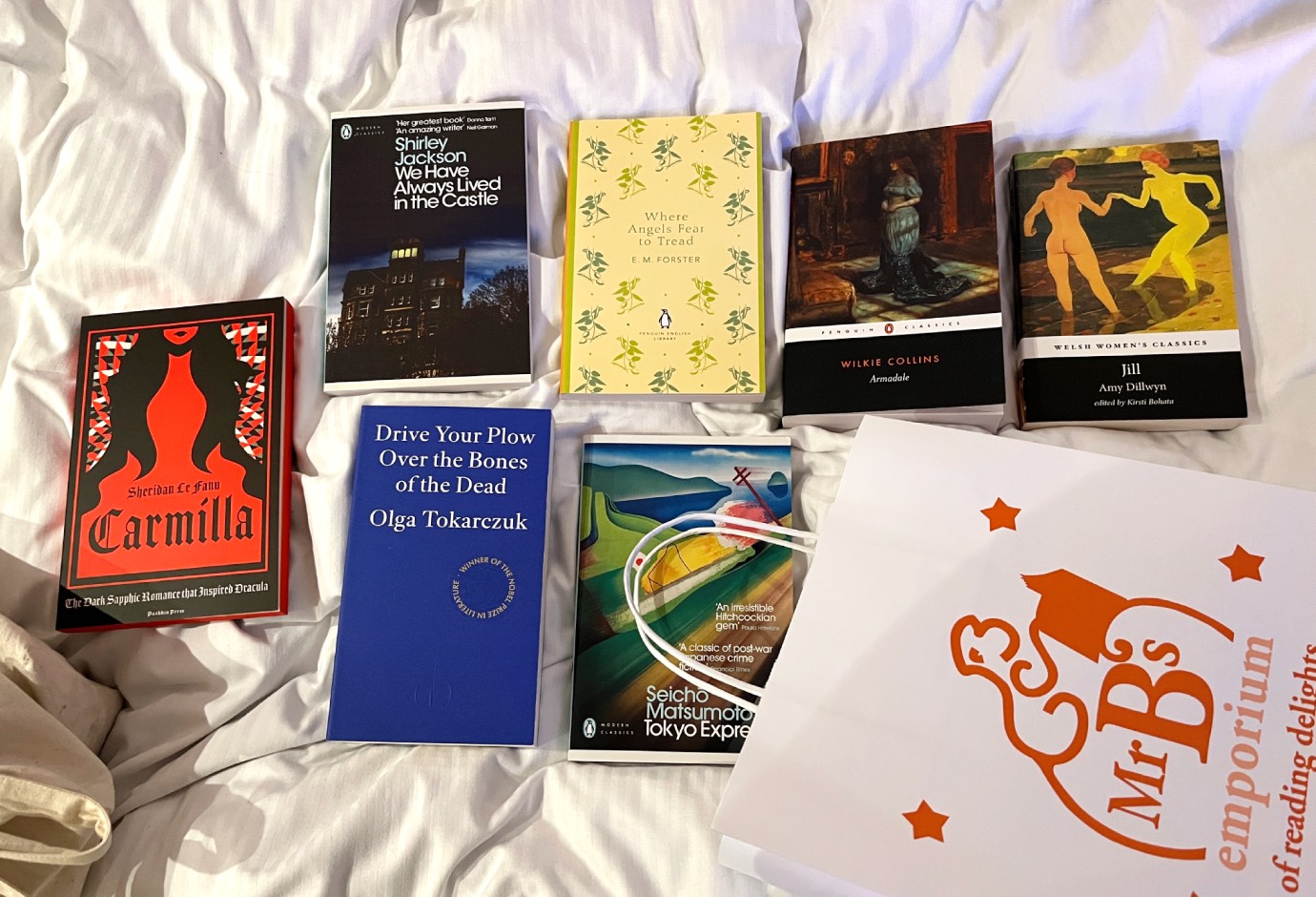 Photo of books spread out on a hotel bed.